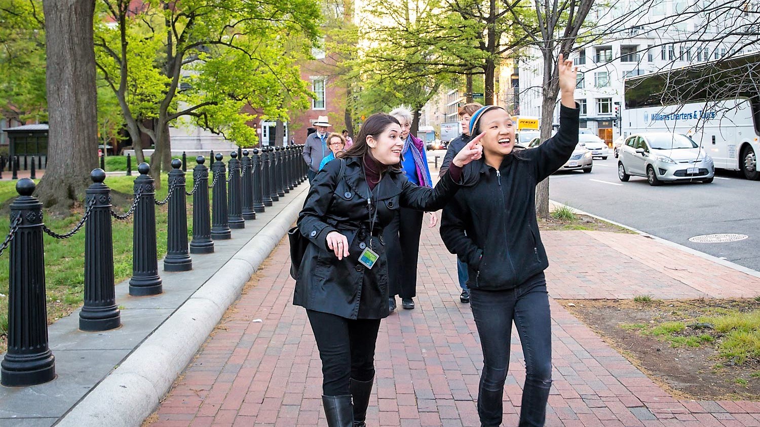 An animated guide points at a feature to a walk participant on a Washington DC walking tour